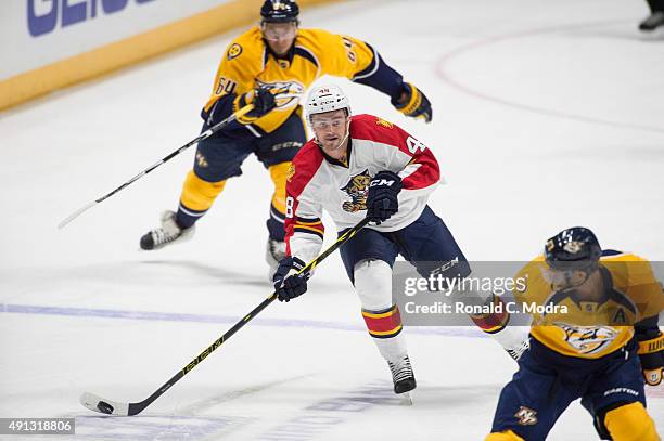 Logan Shaw of the Florida Panthers skates with the puck as Victor Bartley the Nashville Predators chases during a game at Bridgestone Arena on...