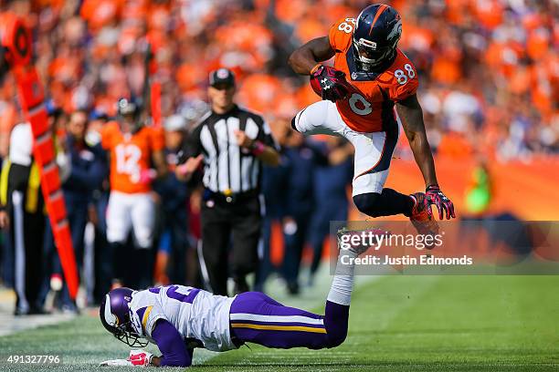 Wide receiver Demaryius Thomas of the Denver Broncos flies through the air after being hit by cornerback Terence Newman of the Minnesota Vikings on a...