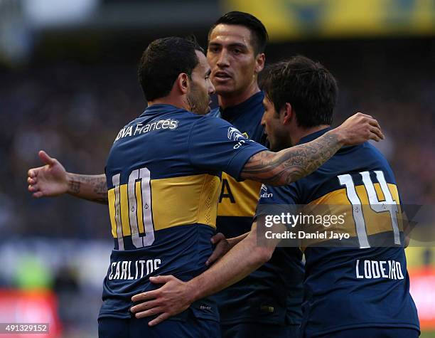 Carlos Tevez of Boca Juniors celebrates with his teammates after forcing an own goal by Gabriel Tomassini of Crucero del Norte during a match between...