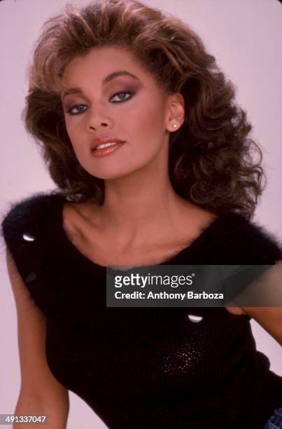 Portrait of American model, actress, and singer Vanessa L. Williams as she poses against a pink background, mid 1980s or early 1990s.