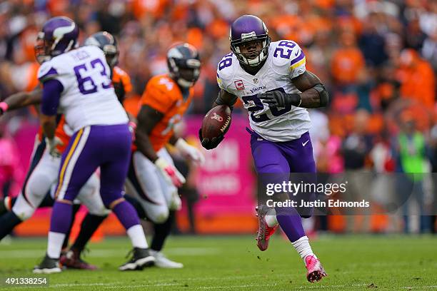 Running back Adrian Peterson of the Minnesota Vikings rushes for a 48 yard touchdown against the Denver Broncos in the fourth quarter of a game at...