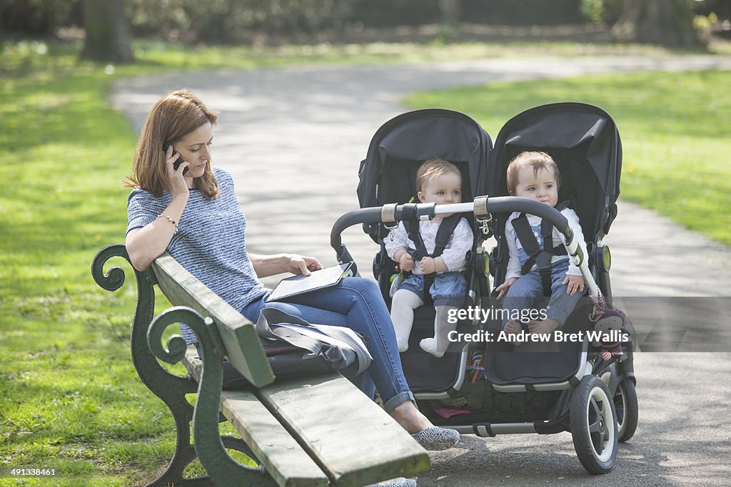 Mother working from the park with her young family