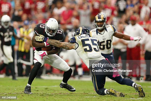 Wide receiver Jaron Brown of the Arizona Cardinals is hit by middle linebacker James Laurinaitis of the St. Louis Rams during the second half of the...