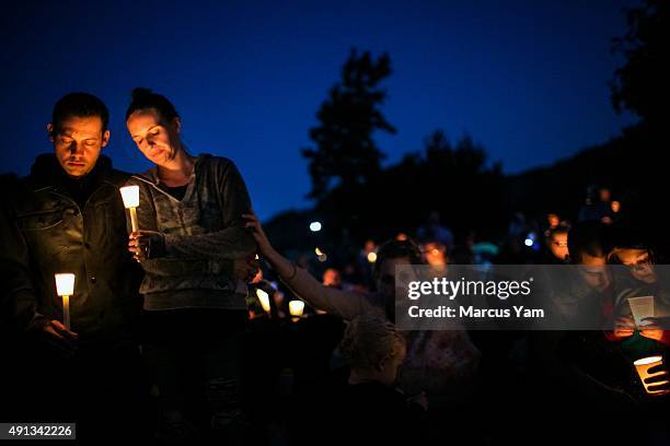 Community members hold a candlelight vigil during a memorial service called 'Prayers for Roseburg,' which is organized in response to the recent...