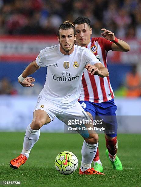 Gareth Bale of Real Madrid in action beside Guilherme Siqueira of Club Atletico de Madrid during the La Liga match between Club Atletico de Madrid...