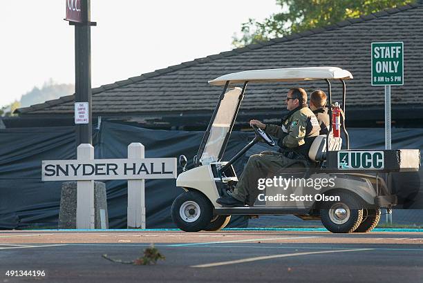 Sheriff's officers patrol outside Snyder Hall, which is surrounded by a black tarp, on the campus of Umpqua Community College on October 4, 2015 in...