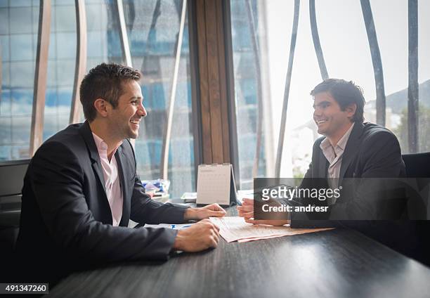 successful business men in a meeting looking happy - transfer of licence agreement stockfoto's en -beelden