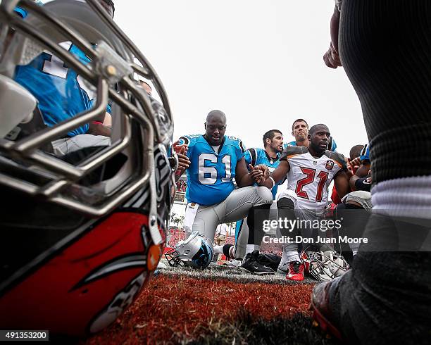 Guard Fernando Velasco of the Carolina Panthers and Cornerback Alterraun Verner the Tampa Bay Buccaneers in the prayer circle after the game at...