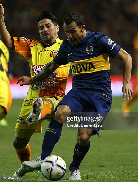 Carlos Tevez, of Boca Juniors, is challenged by Maximiliano Oliva, of Crucero del Norte, during a match between Boca Juniors and Crucero del Norte as...