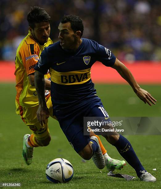 Carlos Tevez, of Boca Juniors, dribbles past Maximiliano Oliva, of Crucero del Norte, during a match between Boca Juniors and Crucero del Norte as...
