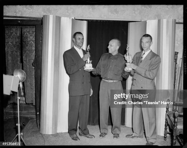 Pittsburgh Courier columnist Earl Johnson presenting Courier baseball tournament trophies to baseball team managers Evan Smalley and Harold Tinker,...