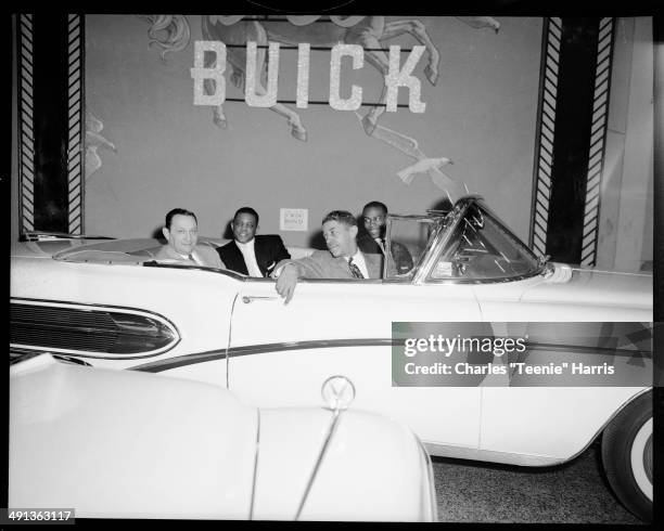 San Francisco Giants baseball player Willie Mays with Monte Irvin, Mal Goode, and another man seated in Air Born B-58 Buick convertible car,...