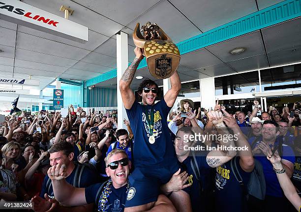 Johnathan Thurston of the Cowboys is hoisted onto the shulders of Ben Hannant and Kane Linnett with the NRL trophy after arriving back at the...