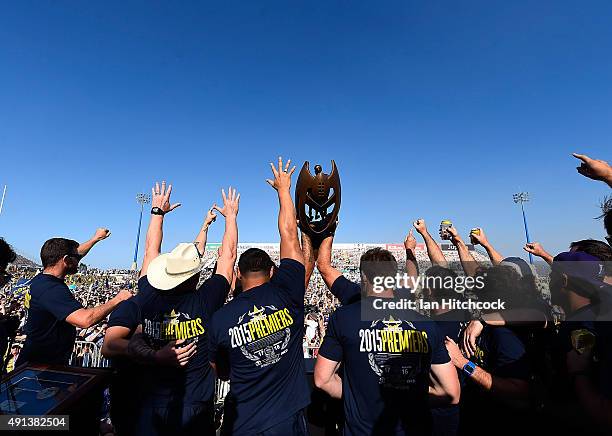 The Cowboys team hold aloft the NRL trophy on stage during the North Queensland Cowboys NRL Grand Final fan day at 1300 Smiles Stadium on October 5,...