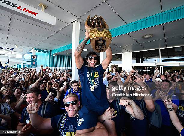 Johnathan Thurston of the Cowboys is hoisted onto the shoulders of Ben Hannant and Kane Linnett with the NRL trophy after arriving back at the...