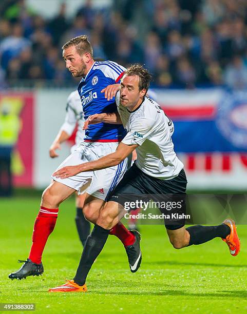 Marc Heider of Holstein Kiel challenges Steffen Puttkammer of 1. FC Magdeburg during the 3. League match between Holstein Kiel and 1. FC Magdeburg at...