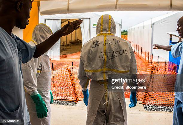 Healthcare worker wearing Personal Protective Equipment is directed to a tent at an Ebola Treatment Center in Coyah, Guinea, on Thursday, Sept. 10,...