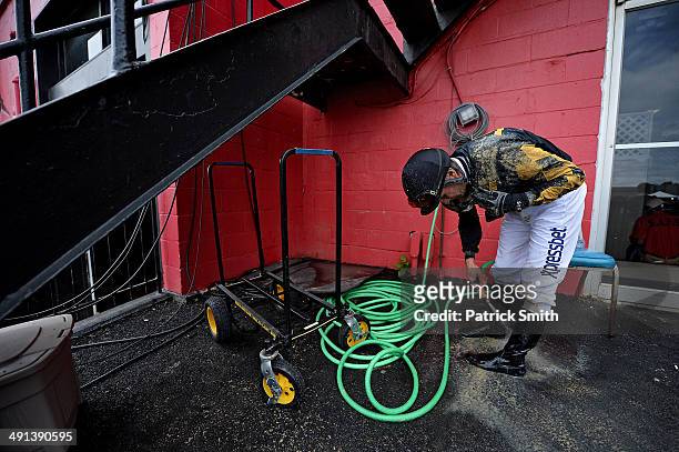 Alex O. Solis, jockey of Sky Given, rinses off after a Black-Eyed Susan Day race, a day prior to the 139th Preakness Stakes at Pimlico Race Course on...