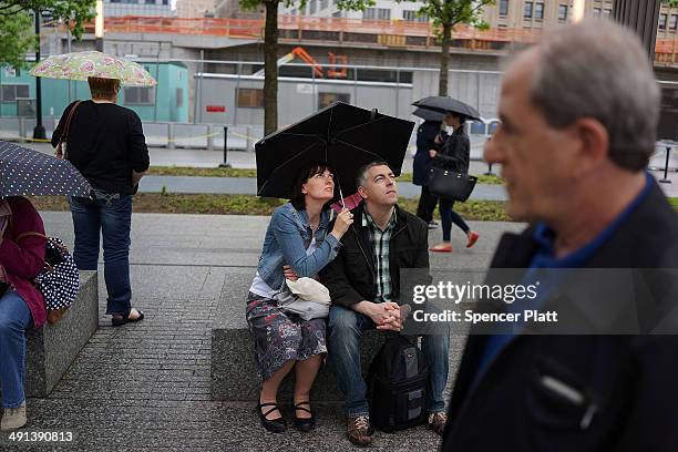 Tourists look up as they enter the Ground Zero memorial site after authorities opened the plaza to the public free of charge on May 16, 2014 in New...