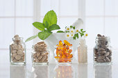 Herbal medicine pills and mortar over bright  background