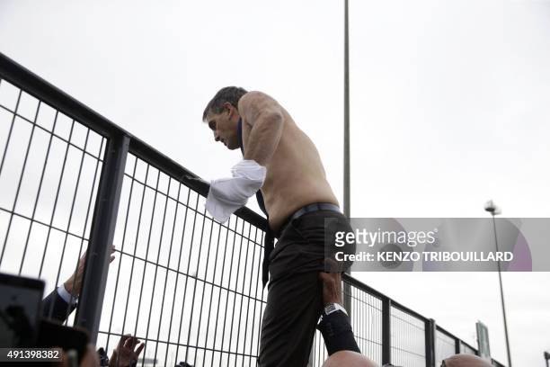 Air France Executive Vice President in charge of Human Resources and Labour Relations Xavier Broseta, shirtless, tries to cross a fence, helped by...