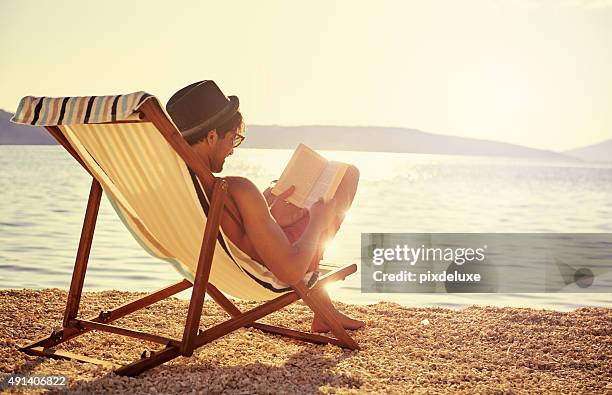 getting lost in a good book - beach book reading stockfoto's en -beelden