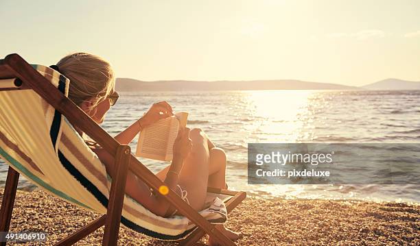 entspannen sie sich mit einem guten buch in einer wunderschönen umgebung - beach holiday stock-fotos und bilder
