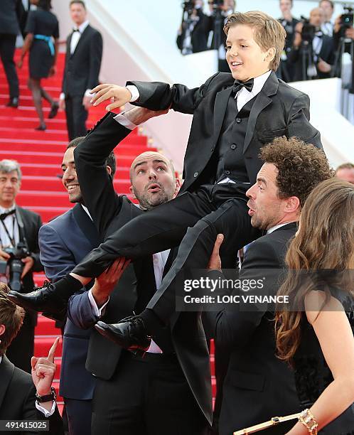 French actors Tarek Boudali, Julien Arruti and Gregoire Ludig carry actor Enzo Tomasini next to French actress Alice David as they arrive for the...