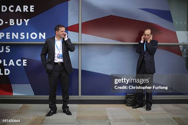 Delegates check their phones during the second day of the Conservative Party Conference at Manchester Central on October 5, 2015 in Manchester,...