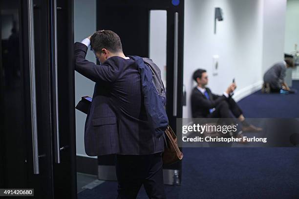 Delegates check their phones during the second day of the Conservative Party Conference at Manchester Central on October 5, 2015 in Manchester,...