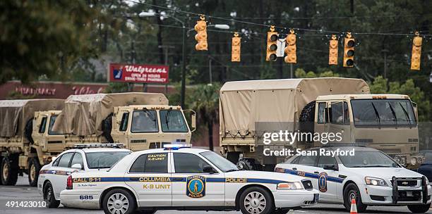 Military vehicles make their way through a police roadblock on Garners Ferry Road following flooding in the area October 5, 2015 in Columbia, South...