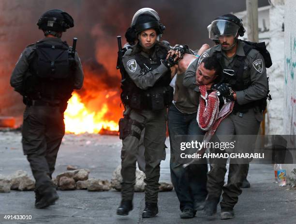 Israeli security forces arrest a Palestinian during clashes in the Palestinian neighborhood of Shuafat in east Jerusalem on October 5, 2015 as...