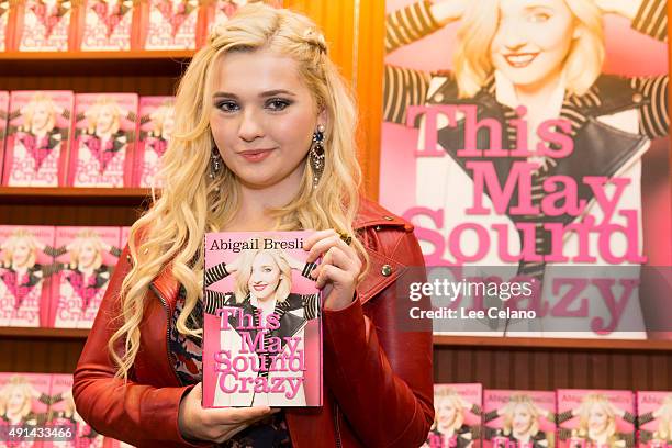 Abigail Breslin shows a copy of her new book "This May Sound Crazy" during a book signing on October 4, 2015 in Metairie, Louisiana.