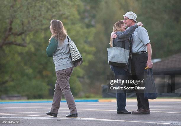 Staff members embrace as they arrive on the campus of Umpqua Community College as it reopens on October 5, 2015 in Roseburg, Oregon. Despite crime...