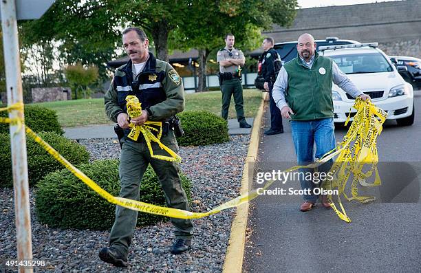 Police officers remove crime scene tape on the campus of Umpqua Community College as it reopens on October 5, 2015 in Roseburg, Oregon. The campus...