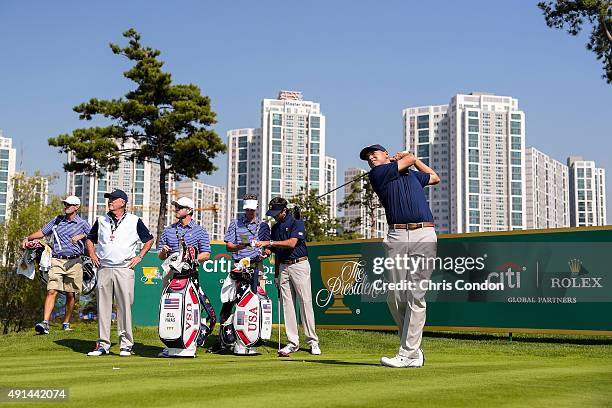 Bill Haas of Team USA tees off on the seventh hole as caddies and teammates Brandon Parsons, Captain Jay Haas, John Wood, Ted Scott and Bubba Watson...