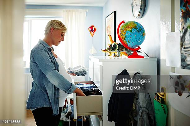 pregnant woman arranging the wardrobe - keep home clean stock pictures, royalty-free photos & images