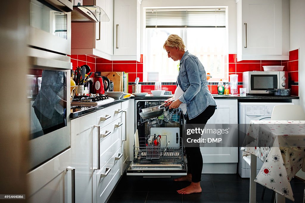 Pregnant woman emptying the dishwasher