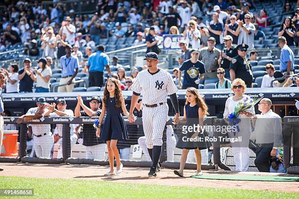 Alex Rodriguez of the New York Yankees enters the field with daughters Natasha and Ella during the pre-game ceremony honoring Alex's 3000th hit...