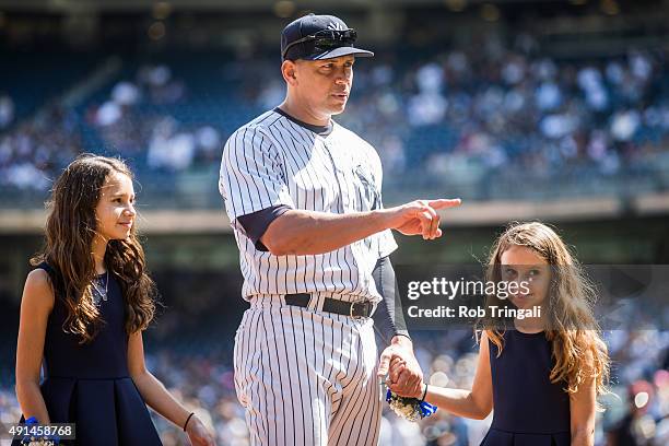 Alex Rodriguez of the New York Yankees enters the field with daughters Natasha and Ella during the pre-game ceremony honoring Alex's 3000th hit...