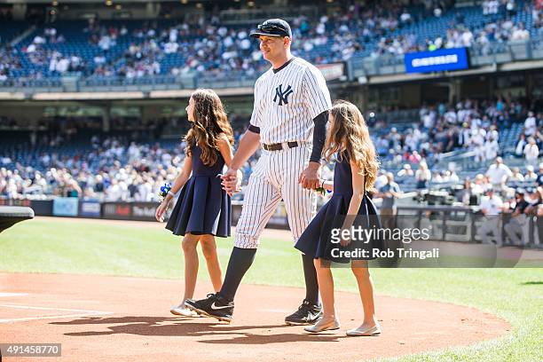 Alex Rodriguez of the New York Yankees enters the field with daughters Natasha and Ella during the pre-game ceremony honoring Alex's 3000th hit...