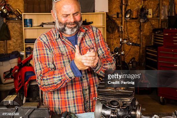 man in a workshop with a hand injury - hand laceration stockfoto's en -beelden