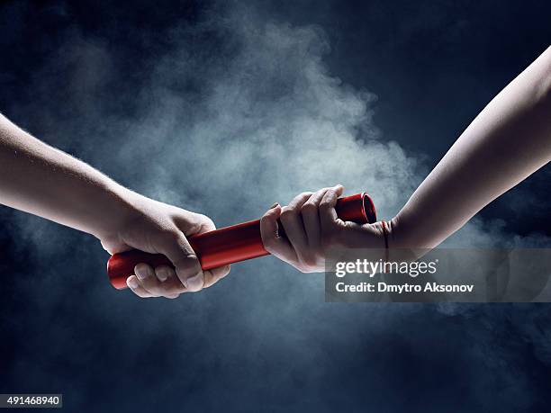 close up of exchanging relay baton on a race - estafette stockfoto's en -beelden