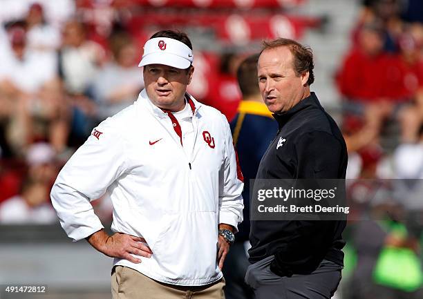 Head Coach Bob Stoops of the Oklahoma Sooners and head coach Dan Holgorsen of the West Virginia Mountaineers meet before the game October 3, 2015 at...