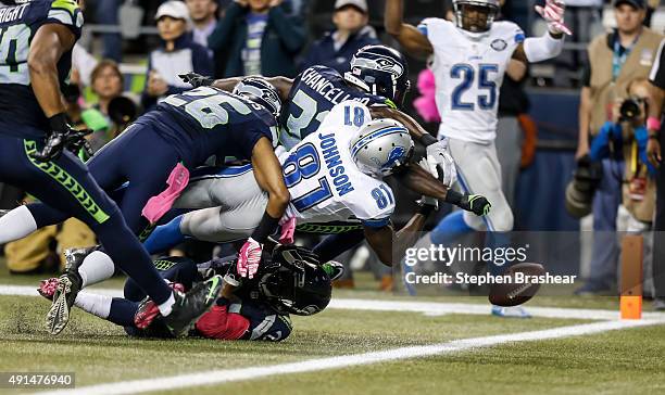 Defensive back Kam Chancellor of the Seattle Seahawks knocks the ball out of the hands of wide receiver Calvin Johnson of the Detroit Lions near the...