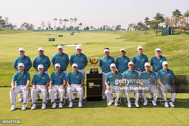 International Team members pose for a group photo with the Presidents Cup trophy on the range during practice for The Presidents Cup at Jack Nicklaus...