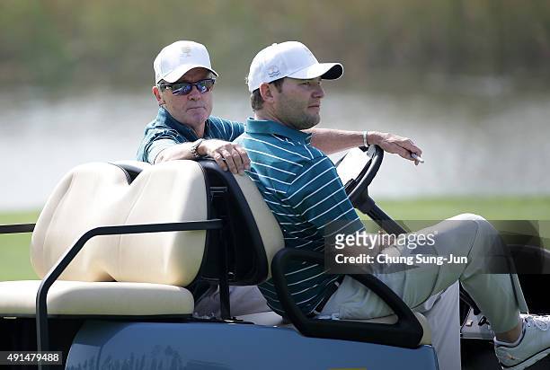 Mark McNulty and Branden Grace of the International Team talk prior to the start of The Presidents Cup at the Jack Nicklaus Golf Club on October 6,...