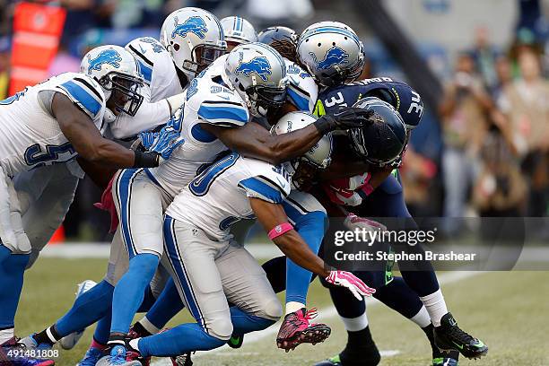 Thomas Rawls of the Seattle Seahawks is brought down by members of the Detroit Lions defense including Josh Wilson of the Detroit Lions, Josh Bynes...