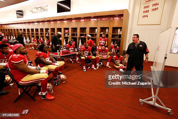 Head Coach Jim Tomsula of the San Francisco 49ers talks with the defense in the locker room at halftime during the game against the Green Bay Packers...