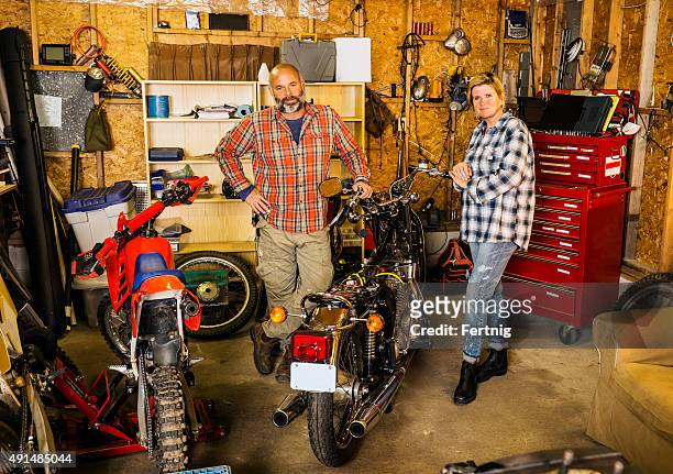 couple in their motorcycle garage - racing garage stock pictures, royalty-free photos & images